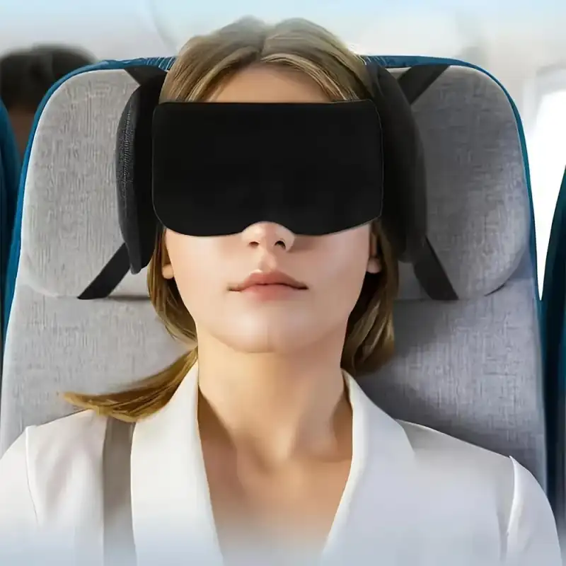 Resenär sover i flygstol med ögonmask som hålls fast mot nackstödet